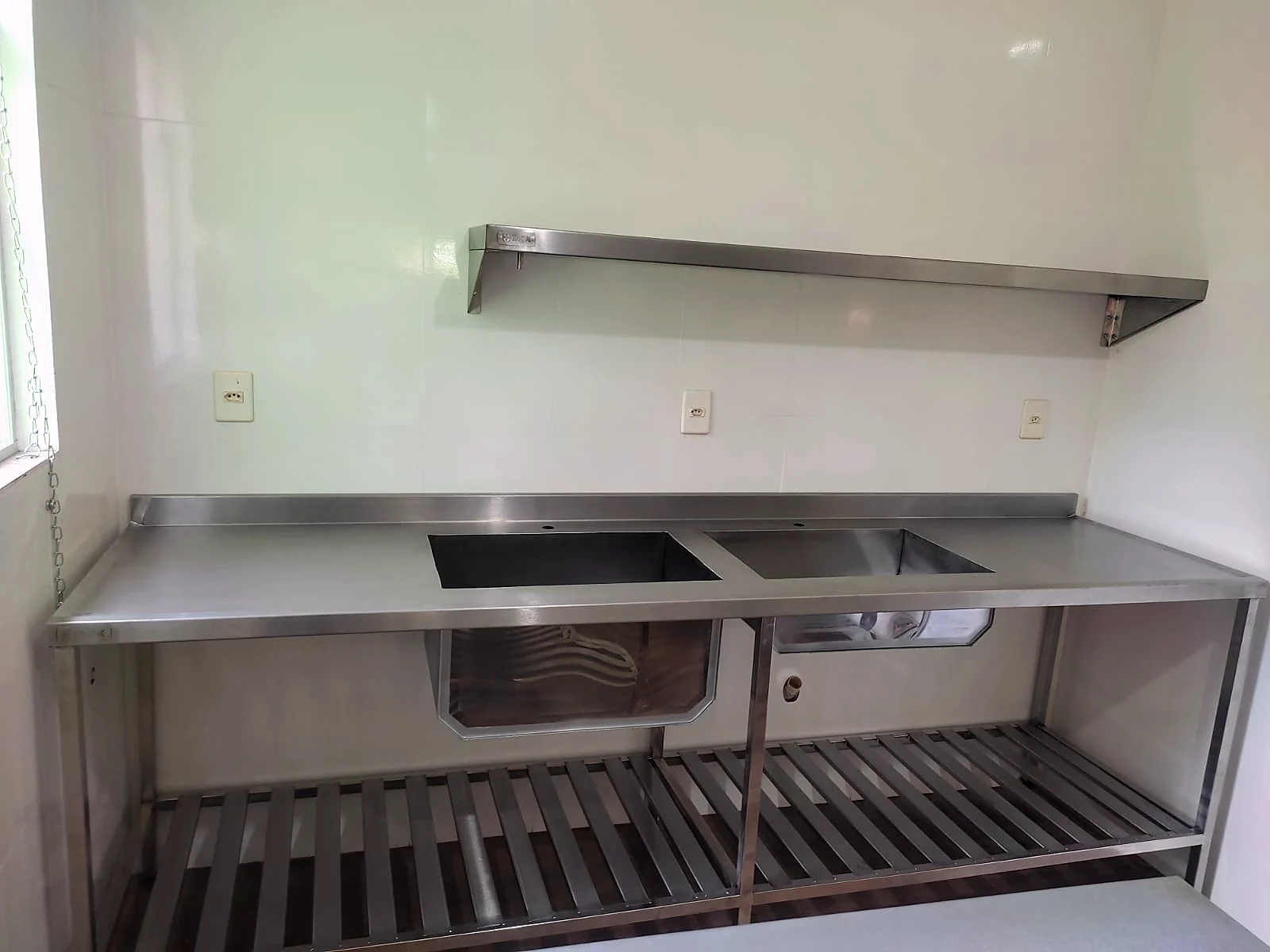Bancada em inox com cuba embutida, prateleira gradeada inferior e prateleira de parede acima