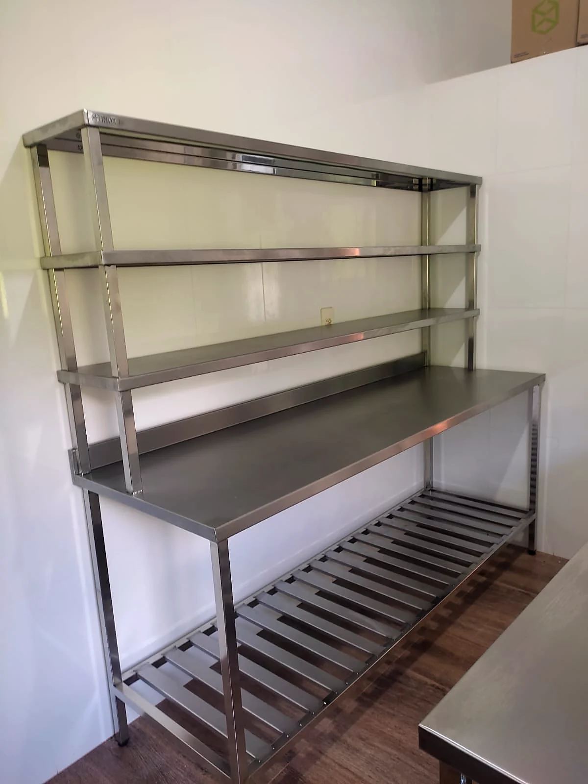 Bancada em inox com duas prateleiras aéreas e prateleira gradeada na parte inferior