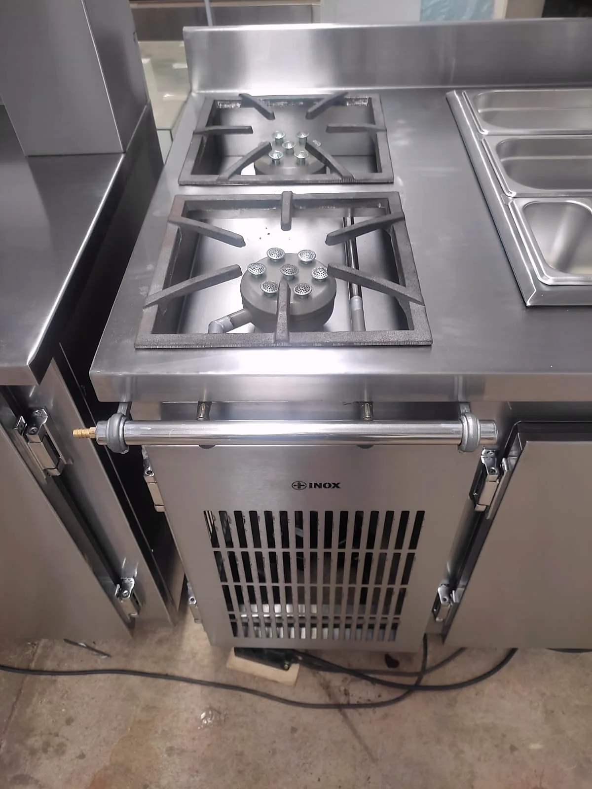 Módulo de cocção em inox com queimadores no tampo e base refrigerada com porta aberta