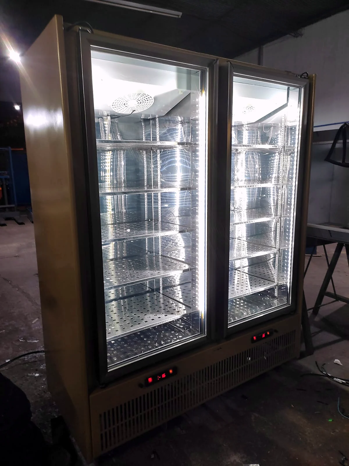 Refrigerador vertical em inox com duas portas de vidro e prateleiras internas ajustáveis