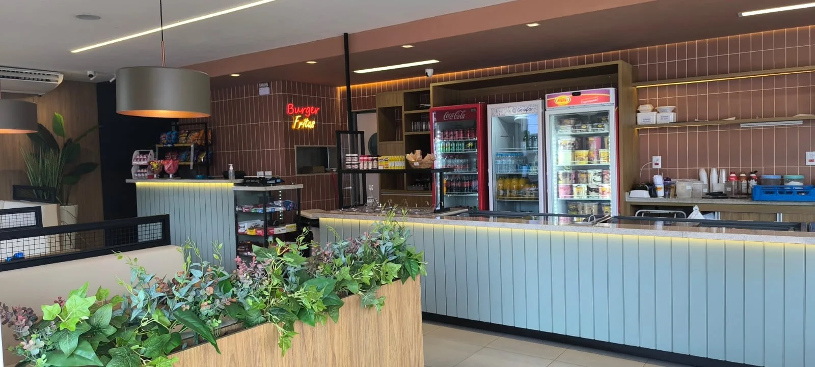 Salão de sorveteria e açaí com balcão de frente ripada e LED sob o tampo, cubas embutidas e refrigeradores verticais ao fundo